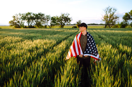 Man hold waving American USA flag. Patriot raise national american flag. Independence Day, 4th July.の写真素材