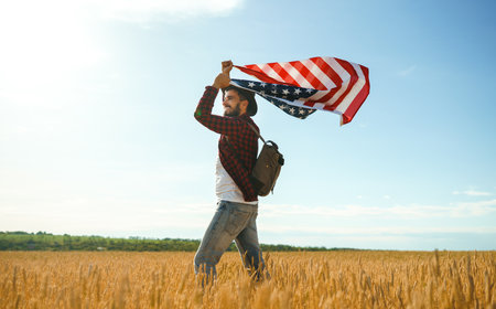 4th of July. American Flag. Traveler with the flag of America. The man in a hat, a backpack, a shirt...