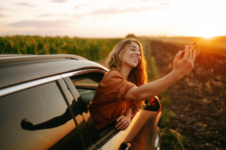 Selfie time. Woman takes selfie in car during road trip. Lifestyle, travel, tourism, active life.の写真素材