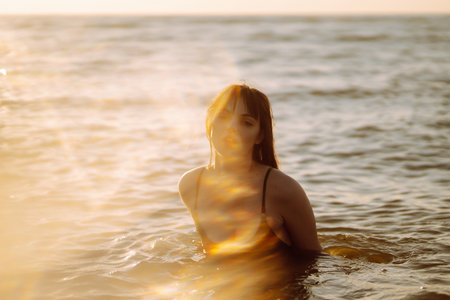 Young woman walks along seashore at sunset. Nature, relax, lifestyle concept.の写真素材