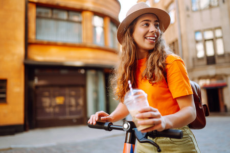 Woman on vacation having fun driving electric scooter through city. Ecological transport concept.の写真素材