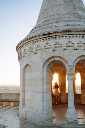 Young female tourist enjoys view of the city at sunset. back view Lifestyle, travel, nature, active lifeの写真素材