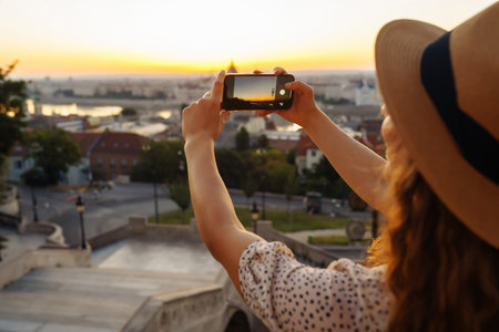 Travel in Europe. Young woman enjoys sunrise. The concept of travel, tourism, vacation and freedom.の写真素材