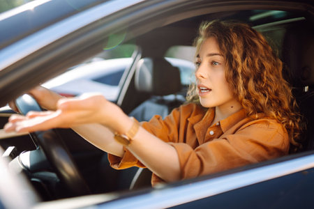 Smiling woman driving a car. Young traveler driving. Car travel, lifestyle concept.の写真素材