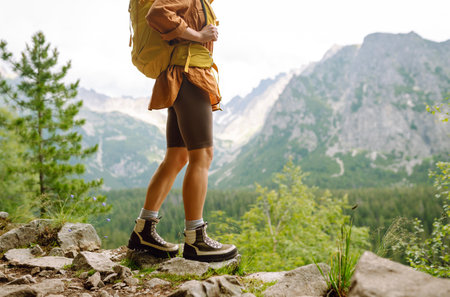 Hiking boot. Close-up of female legs in hiking boots on hiking trail, on top of mountain outdoors.の写真素材