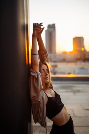 Beautiful woman standing on the roof, feel happy at sunset. Freedom. Lifestyle, relaxation concept.の写真素材