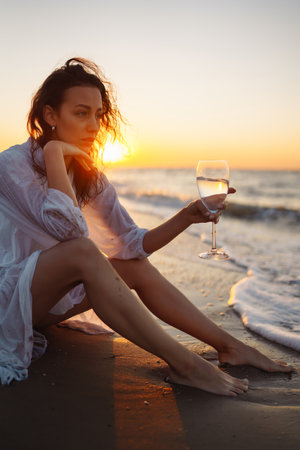 Stylish woman in elegant white dress posing near the sea. People, freedom, lifestyle, travel.の写真素材