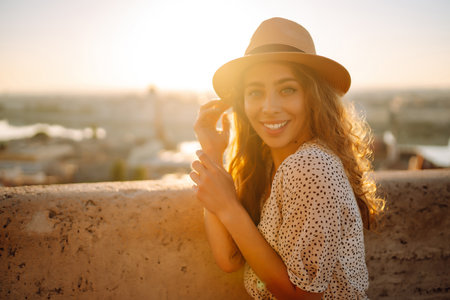 Portrait of happy tourist in hat at dawn enjoys cityscape. Traveling in Europe. Concept tourism.の写真素材