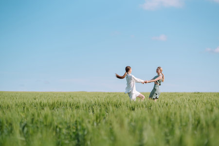 Two Beautiful woman in the green field. Nature, vacation, relax and lifestyle. Summer landscape.の写真素材