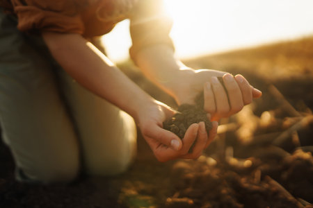 Female hands touching soil on the field. Agriculture, gardening or ecology concept
