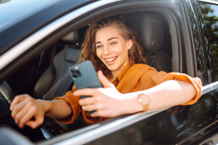 The driver of the car uses a smartphone. Leisure, travel, technology, navigation.の写真素材