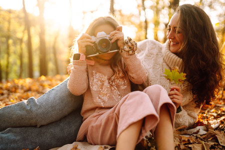 Portrait of happy mother and daughter in autumn forest at sunset. . Autumn women.の写真素材
