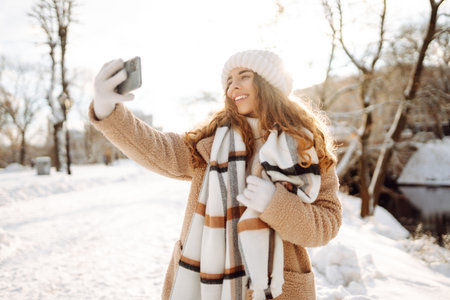 Young woman taking selfie in winter street. Holidays, rest, blogging.の写真素材