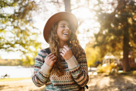 Stylish woman enjoying autumn weather in the sunny park. Enjoying nature. Fashion, style concept.の写真素材