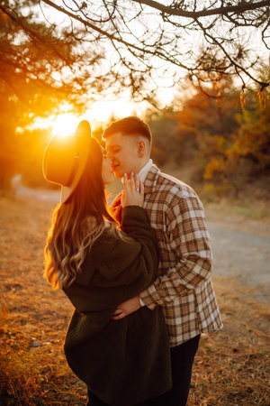 Happy couple in love newlyweds travel together, hike and walk in the autumn forest in nature.の写真素材