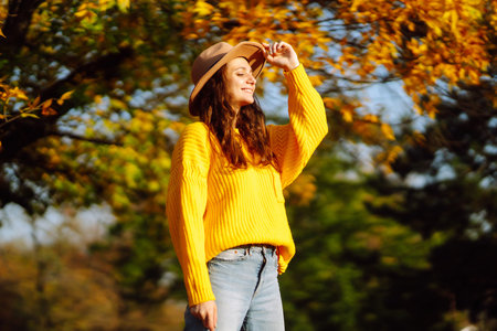 Young woman in a yellow sweater and jeans resting in nature. Fashion, style concept. People,...