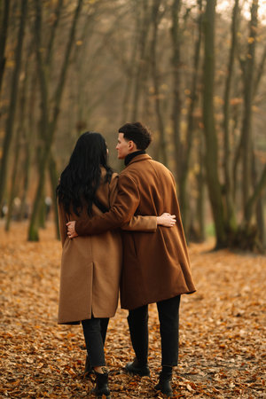 Young couple in love walking in the park on an autumn day. Enjoying time together.の写真素材