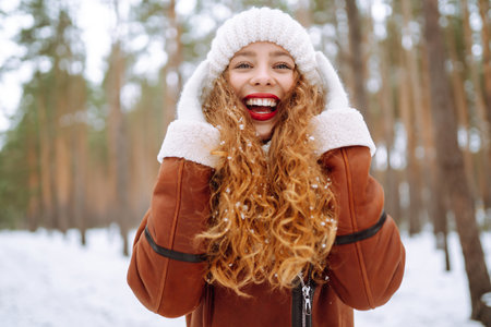 Happy young woman in the winter forest. Christmas, winter holidays concept.の写真素材