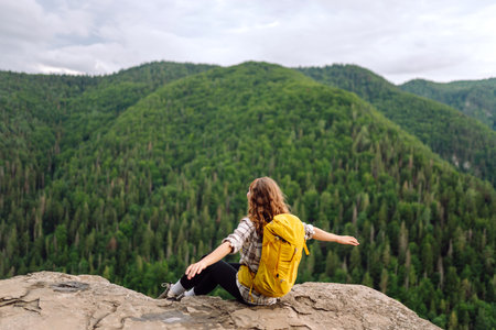 Traveler observes mountain scenery from cliff, view of European troll tongue. Concept of freedom.の写真素材