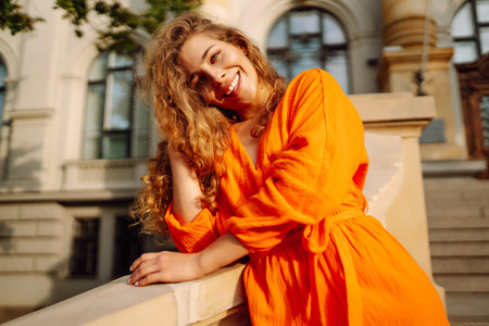 Person in bright orange dress against backdrop of urban landscape. Concept of lifestyle.の写真素材