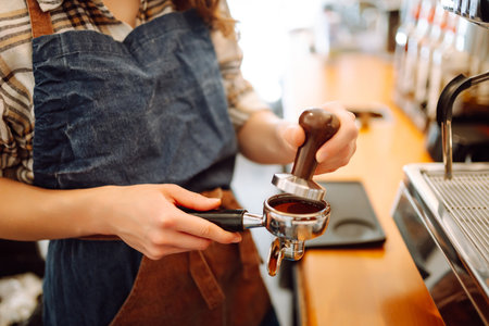 Portrait of a young barista woman making fresh coffee. Takeaway food. Small business concept.の写真素材