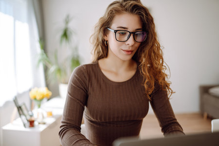 Business woman in casual clothes works with a laptop and notepad. Concept of education, freelancing.の写真素材