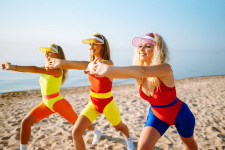 Smiling dancers in colorful swimsuits are dancing on beach ?concept of sports, aerobics. Active sportの写真素材