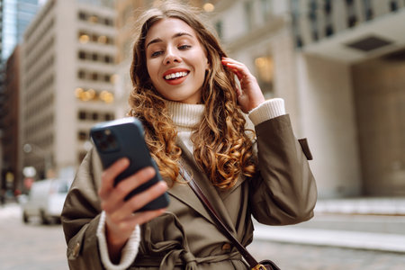 Portrait of happy woman with smartphone in the street city. Concept of blogging, technology, weekendの写真素材
