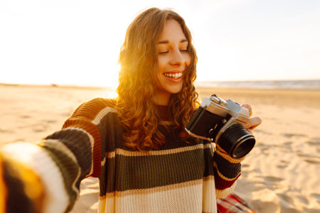 Selfie time. Young woman posing by the sea at sunset. Travel blog. Adventure, vacation concept.