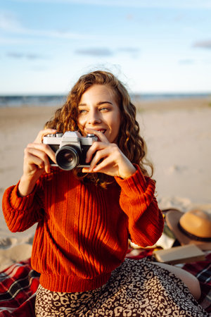 Happy woman with retro camera on the beach. Travel, weekend, relax and lifestyle concept.の写真素材