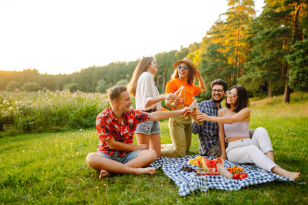 Happy group of friends resting in nature in picnic. People, lifestyle, relaxation, vacations concept.の写真素材