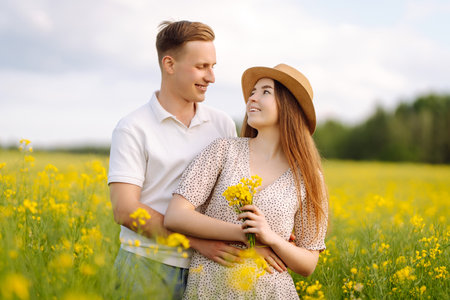 Young couple in love walks through a rapeseed field. The concept of love, relationship.の写真素材