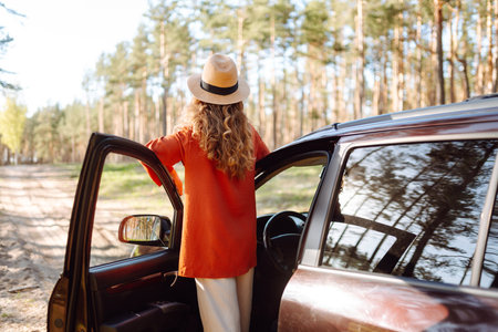 Stopping during a car trip. Young woman enjoying nature. Journey by car. Lifestyle, travel, tourismの写真素材