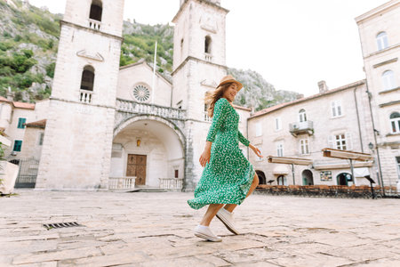 Happy female tourist in beautiful dress walking in the street of the city. Fashion style. Travel.の写真素材