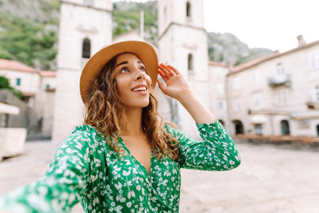 Selfie while traveling. Young woman takes selfie photo on a smartphone. Lifestyle, travel, tourismの写真素材