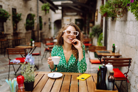 Young woman tourist drinks coffee in the old town in summer trip. People, fashion, lifestyleの写真素材