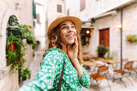 Beautiful woman walks the streets and takes selfie using smartphone cameraの写真素材