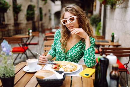 Portrait of a smiling woman eating outdoors.の写真素材