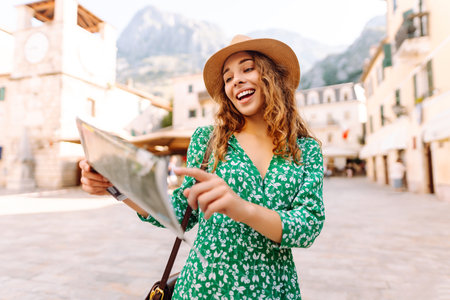 Portrait beautiful woman with paper map on urban street. Exploring interesting places to travel.の写真素材