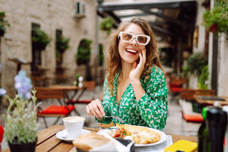 Portrait of a smiling woman eating at cozy restaurant outdoors.の写真素材