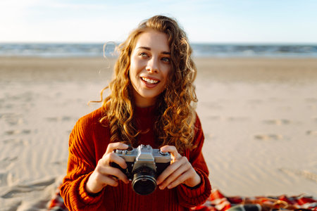 Happy woman with retro camera on the beach. Travel, weekend, relax and lifestyle concept.の写真素材