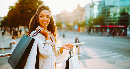 Young woman with shopping bags walking on street. Sale, shopping and happy people concept.の写真素材