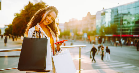Young woman with shopping bags walking on street. Sale, shopping and happy people concept.の写真素材