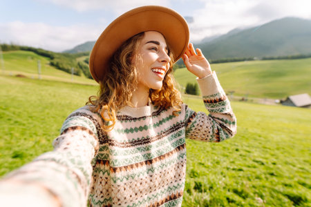 Close-up of a happy woman taking a selfie while hiking. Nature, adventure concept. Active lifestyle.の写真素材