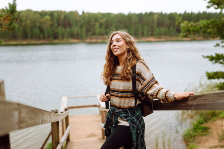 Attractive young woman enjoying fresh air on the lake. Travel, Hiking, natureの写真素材