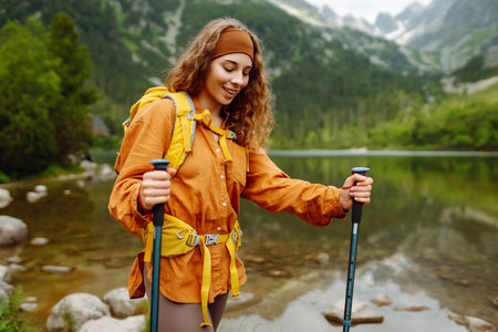 Travel Slovakia, Europe. Tourist with a yellow backpack stands against the backdrop of alpine lake.の写真素材