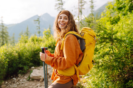 Young woman traveler hiking poles on trail among the mountains. Hiking. Active lifestyle.の写真素材