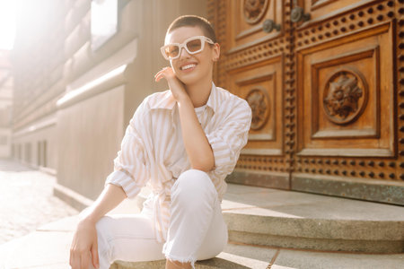 Beautiful woman in stylish clothes and short hair poses. Minimalism, urban style clothes.の写真素材