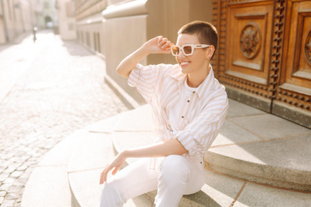 Beautiful woman in stylish clothes and short hair poses. Minimalism, urban style clothes.の写真素材