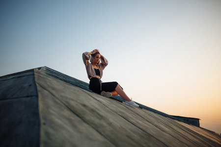 Young woman in roof enjoying sunset, freedom city atmosphere. People, lifestyle, relaxation concept.の写真素材